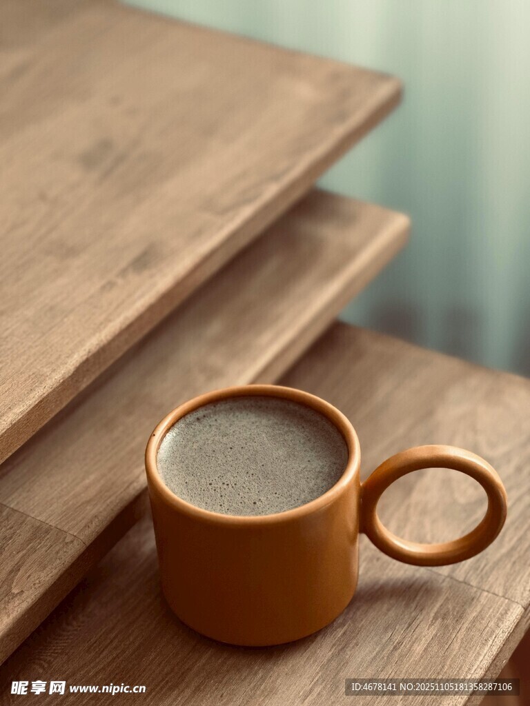 木桌上的棕色咖啡杯