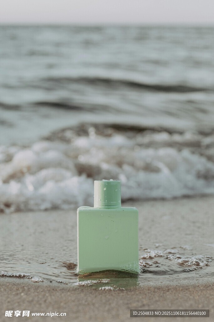海边沙滩上的绿色香水瓶