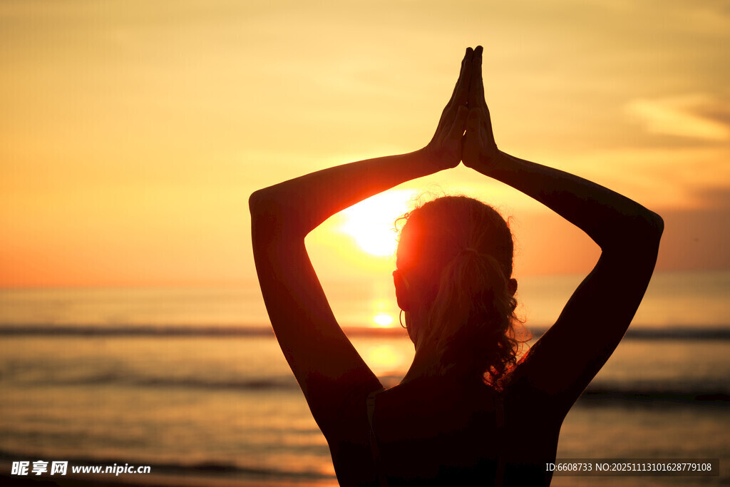 夕阳下海边瑜伽者剪影