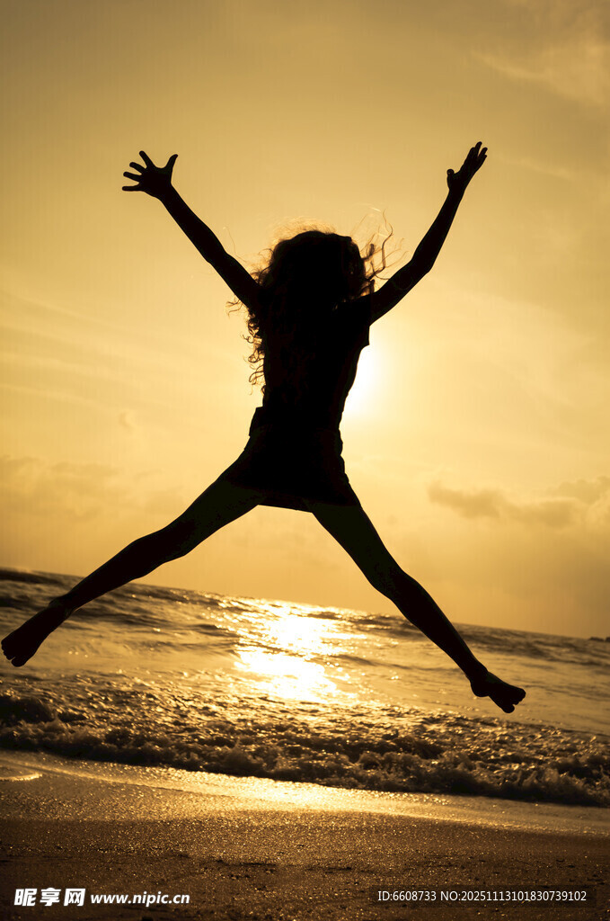 夕阳下海边跳跃的活力身影