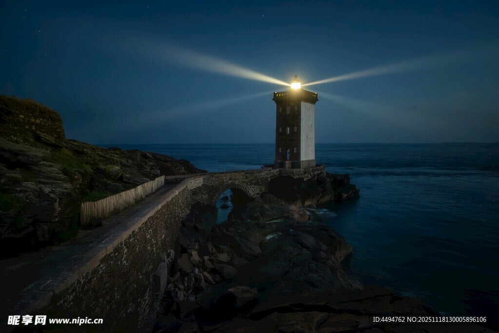 夜幕下的灯塔照亮海岸线