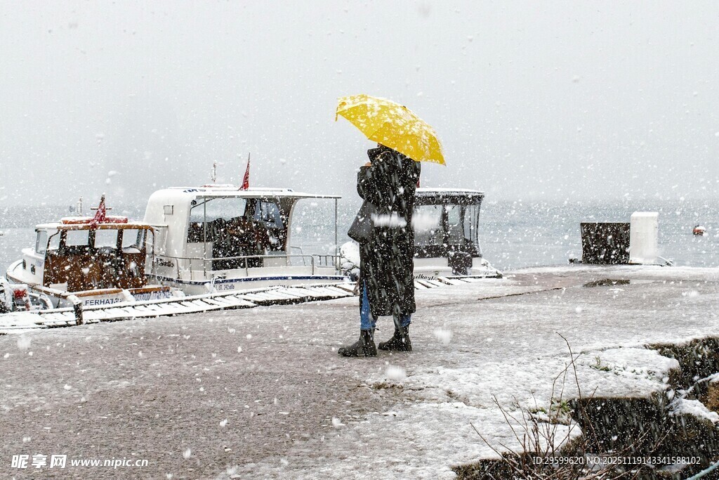 雪中撑黄伞的孤独行人