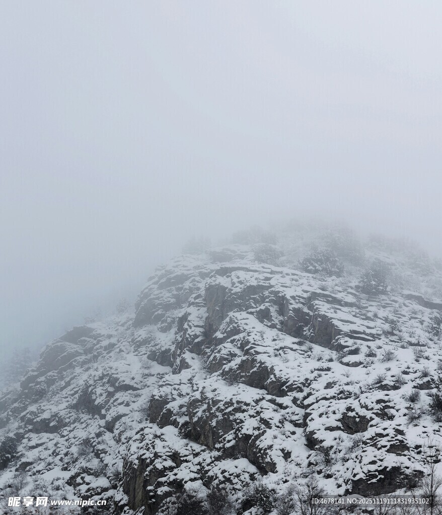 雾中覆雪的嶙峋山峰