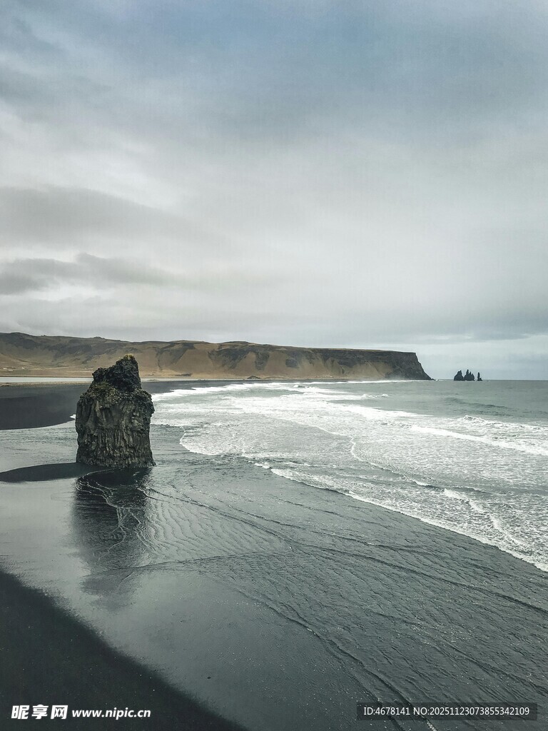 黑沙滩上的海浪与孤石