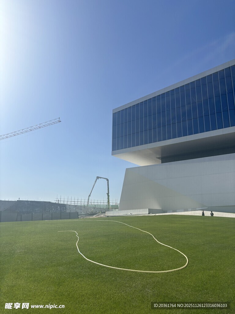 现代建筑旁的绿茵足球场