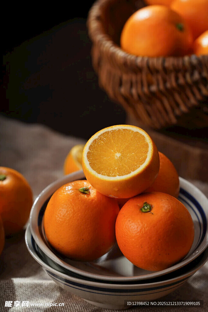 新鲜橙子摆放在盘与篮中