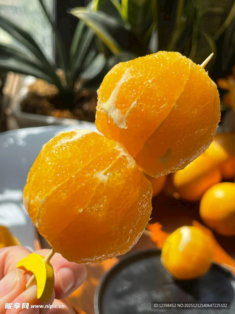 手持两颗剥好的新鲜橙子