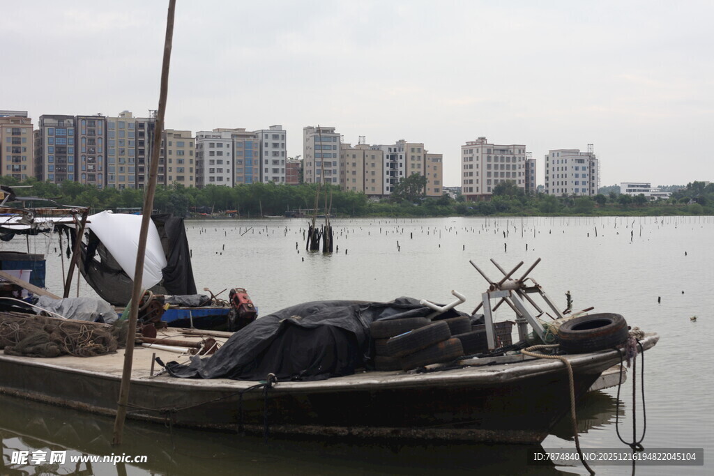 湖畔停泊的渔船与城市远景