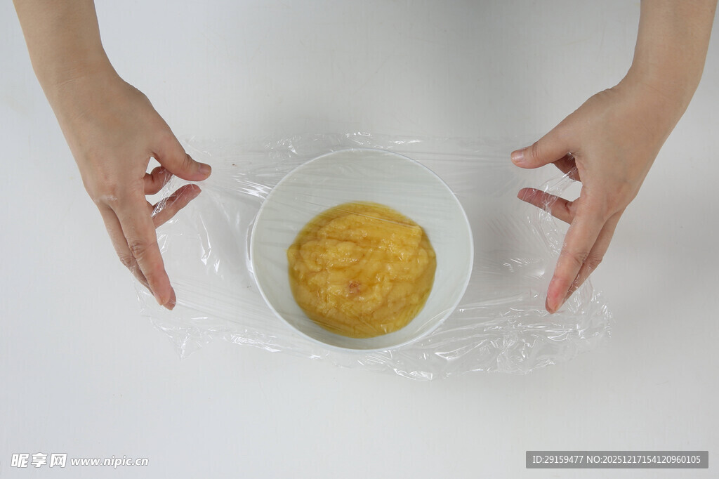 双手搅拌碗中黄色食材