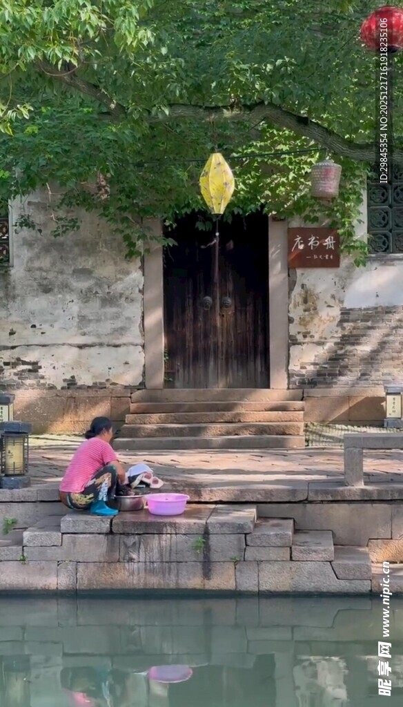 水乡古宅前洗衣的女子