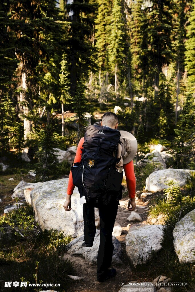 徒步者穿行于林间巨石间