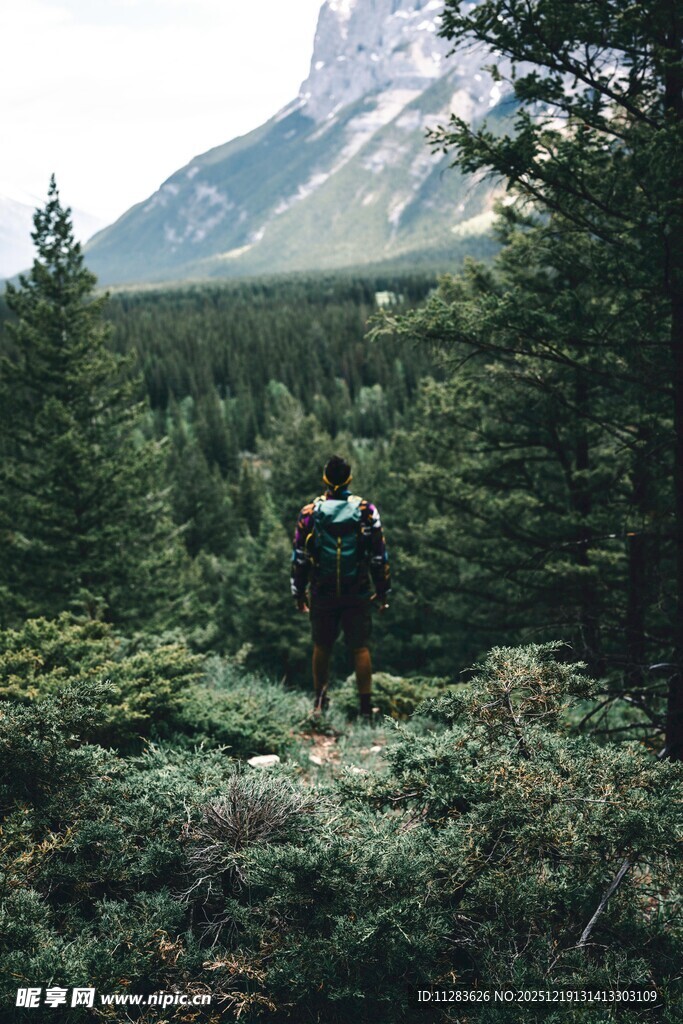 徒步者穿行于山林与雪山间