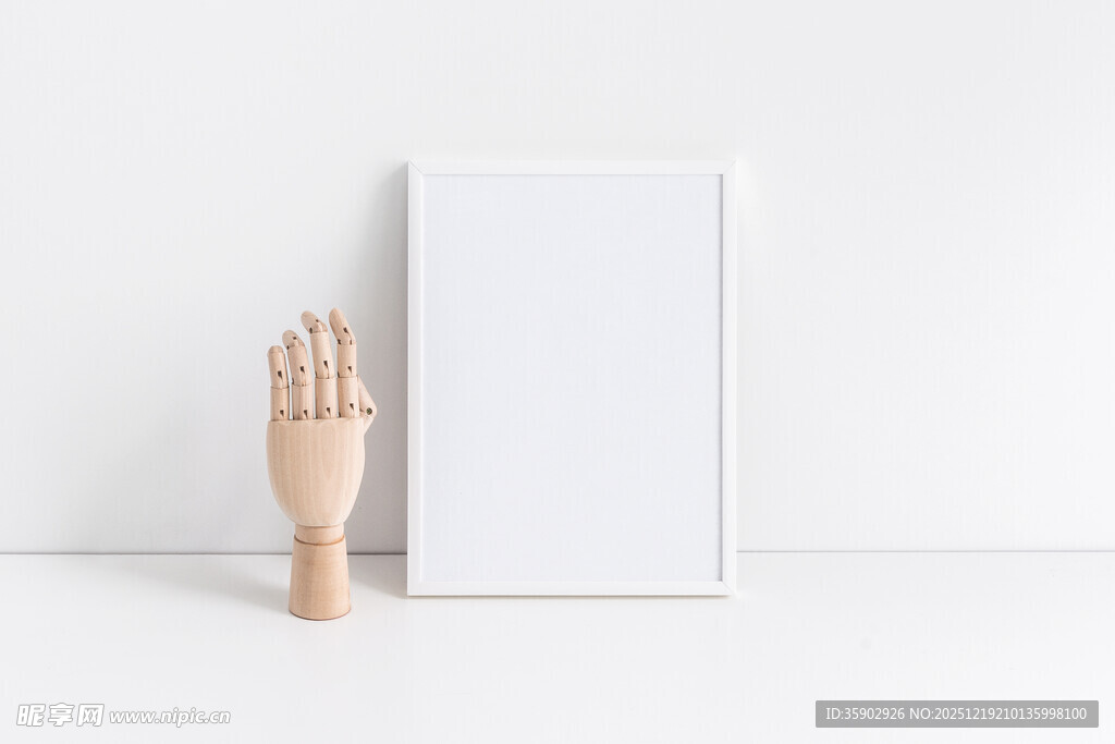 空白画框旁的木质手模型