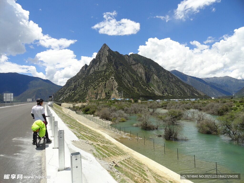 骑行者沿河畔公路赏山景
