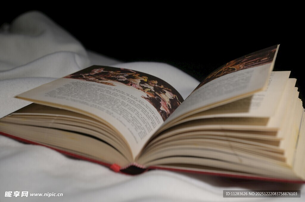 翻开的书置于柔软床面