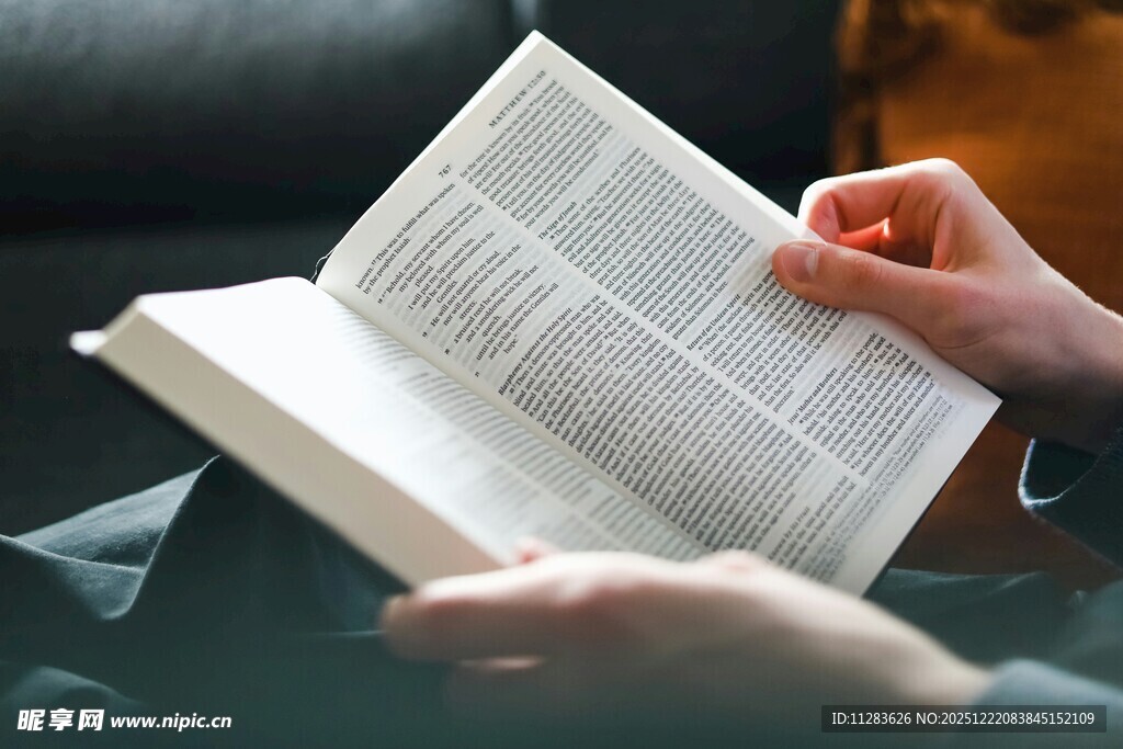 双手捧读翻开的书籍