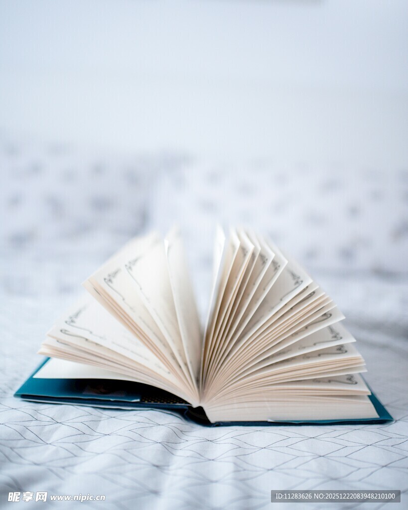 翻开的书置于柔软床面