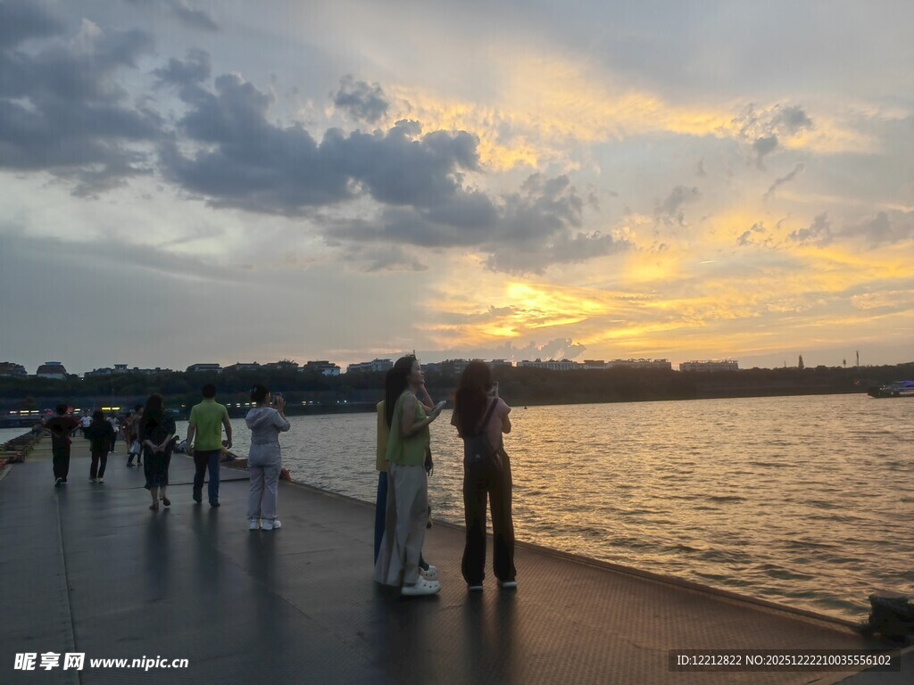 夕阳下湖畔漫步的人群