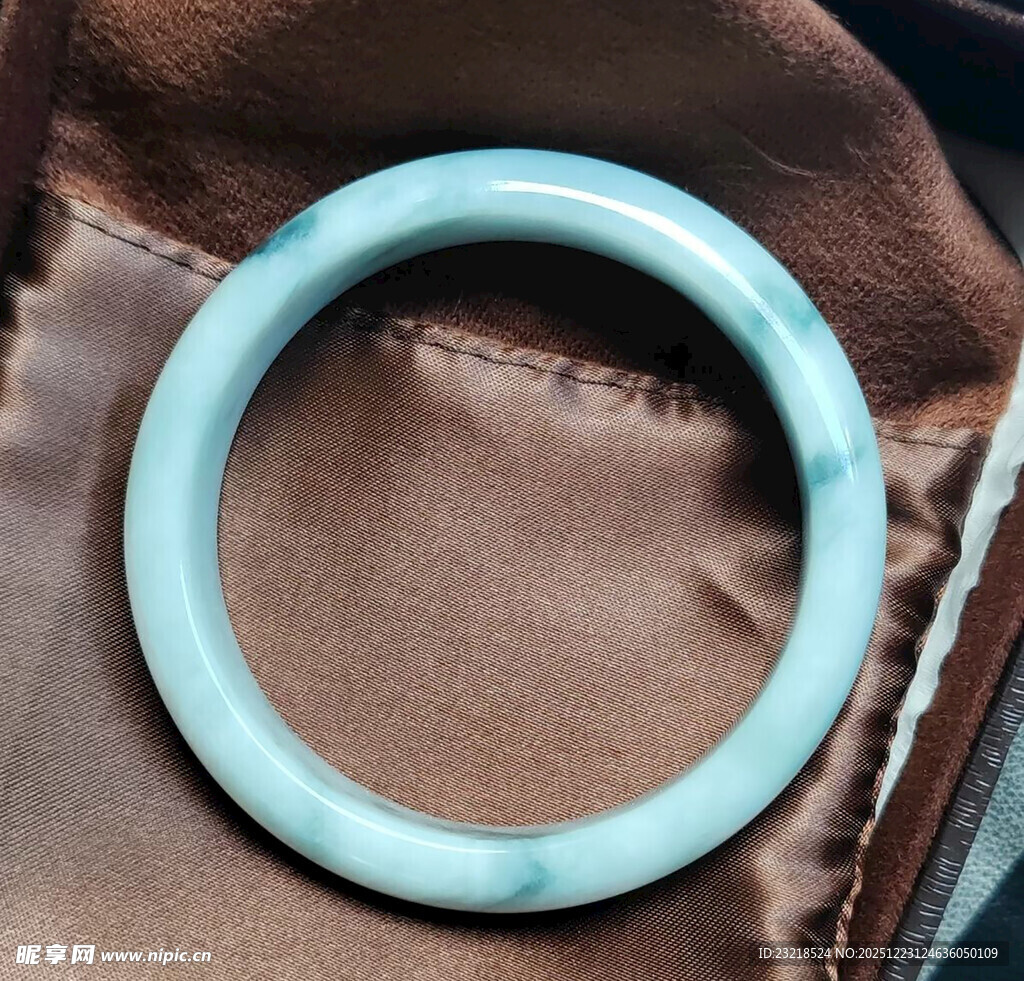 淡蓝色玉镯置于棕色布上
