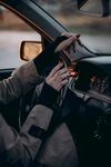 驾车者手握方向盘与手机