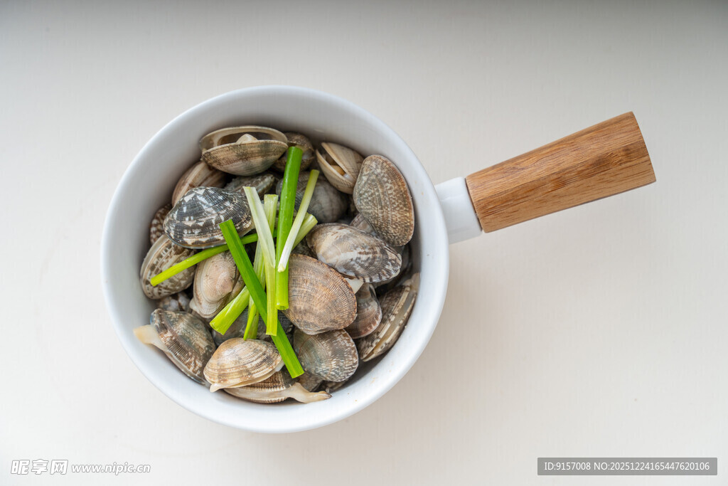 白锅中的蛤蜊与葱段