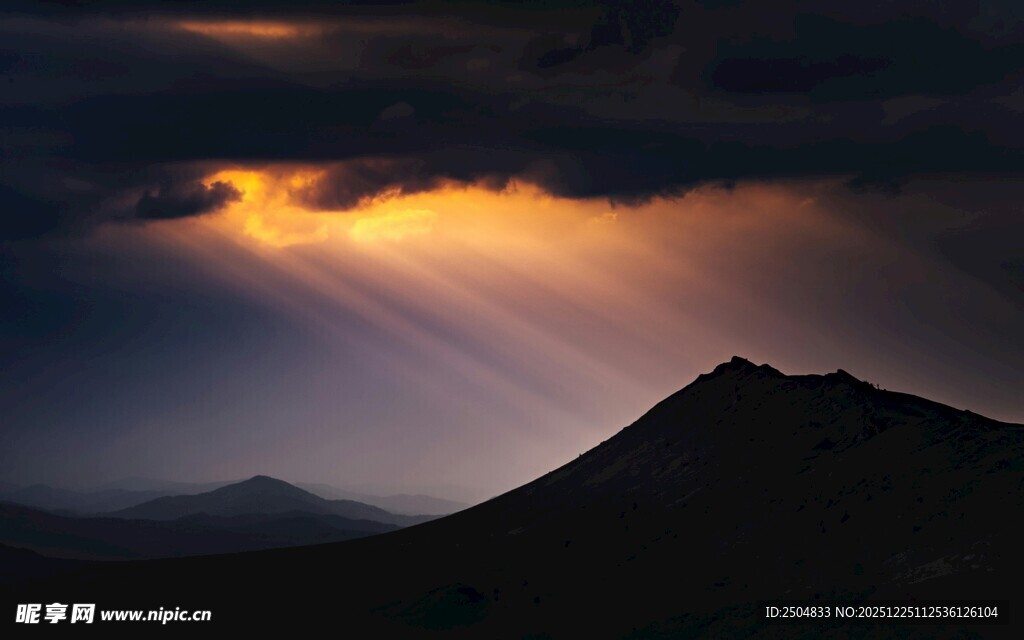 山间穿透乌云的绚丽光束