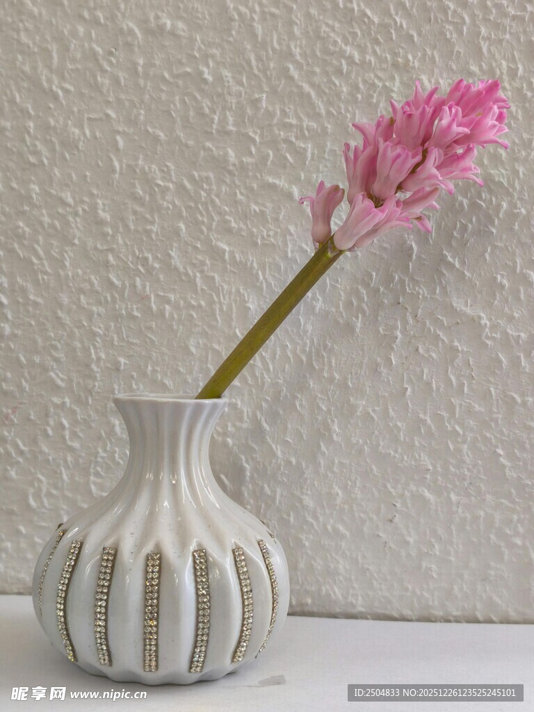 白色花瓶插着粉色花朵