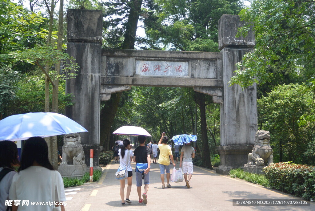 古牌坊下撑伞漫步的人群