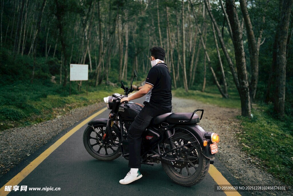 男子骑行于林间公路