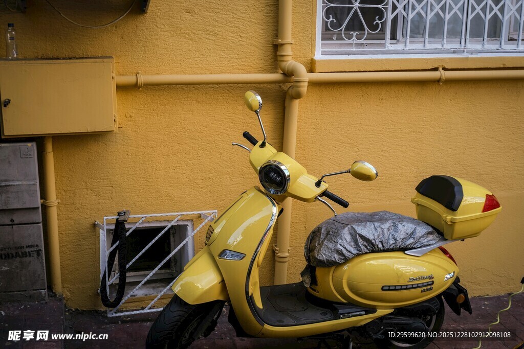 黄色复古踏板摩托车靠墙