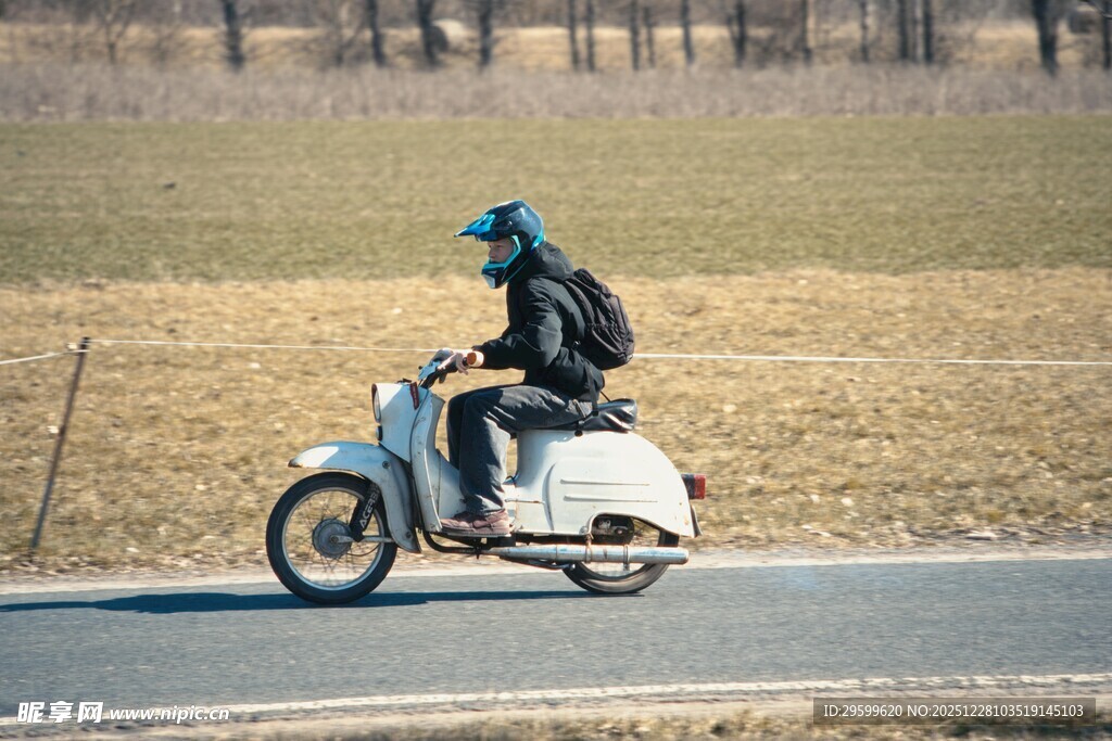 公路上骑行的复古摩托车手