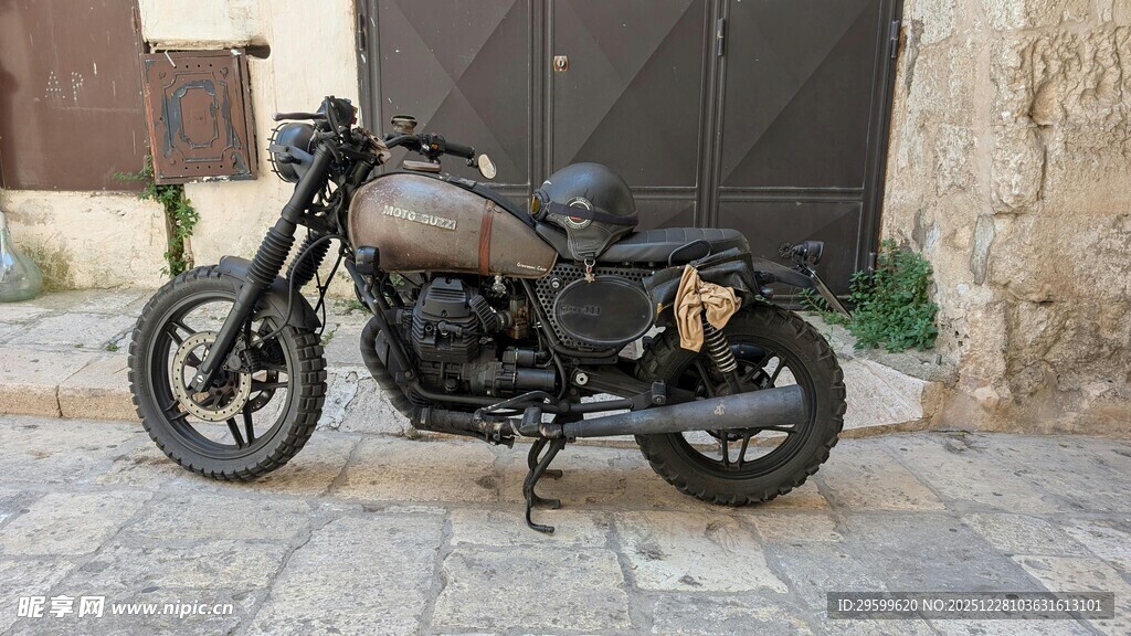 复古摩托车停靠于石砌路旁