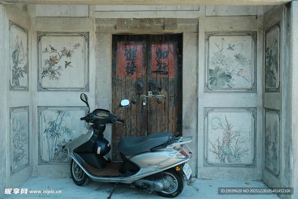 古宅门前的复古踏板摩托车