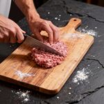 手切肉馅于木砧板之景
