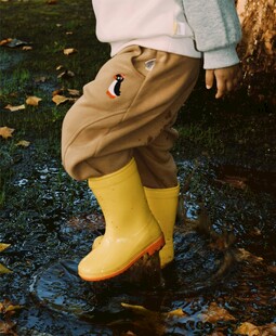 小孩穿黄雨靴踩积水