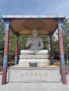 户外佛像坐于彩色亭下