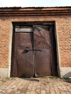 老旧铁门紧闭的砖房一角