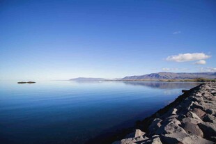 宁静湖畔的石岸与蓝天