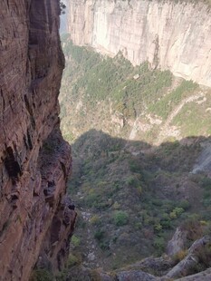 陡峭山壁下的绿意景观