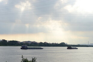 江上船只与穿透云层阳光