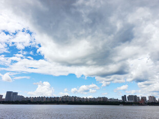 河畔城市天际线与多云天空