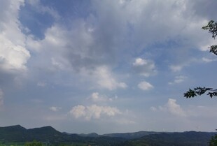 蓝天白云下的山峦与飞鸟