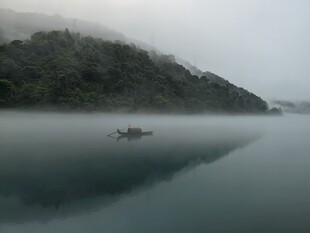 雾中湖面孤舟静谧之景