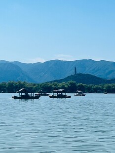 西湖碧波上的船只与远山