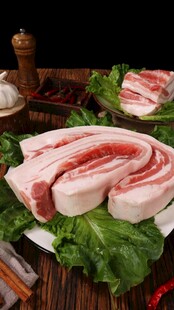 新鲜五花肉摆放在绿叶上