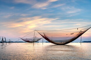 海上夕阳下的巨型捕鱼网