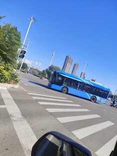 城市道路上行驶的蓝色公交