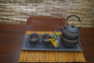 中式茶具摆设于古朴托盘上