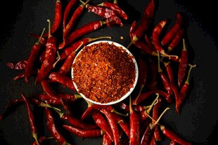 碗中辣椒粉与红辣椒环绕