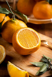 新鲜橙子摆放在木砧板上